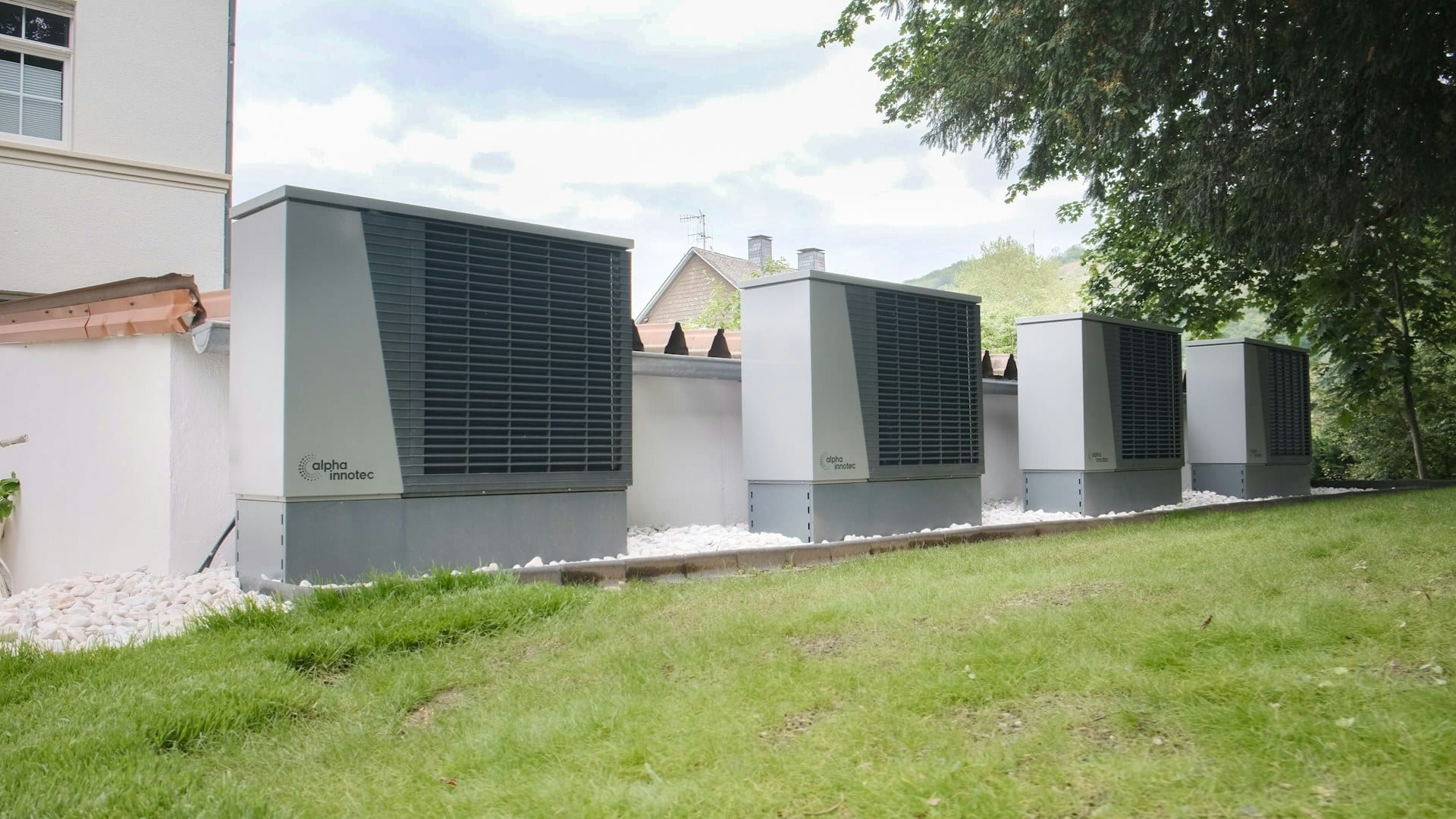 Row of commercial outdoor heat pump units beside a building