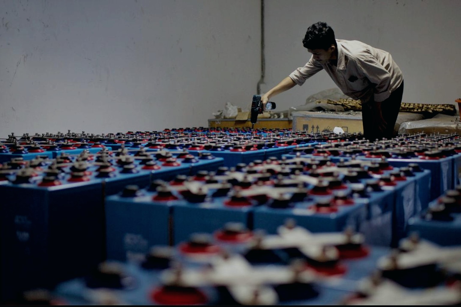 Technician working among rows of battery cells