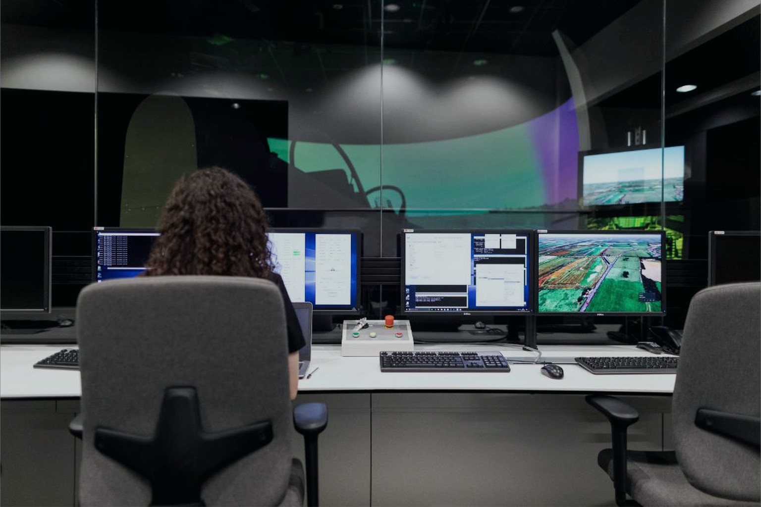 Operator at a desk with several monitoring dashboards